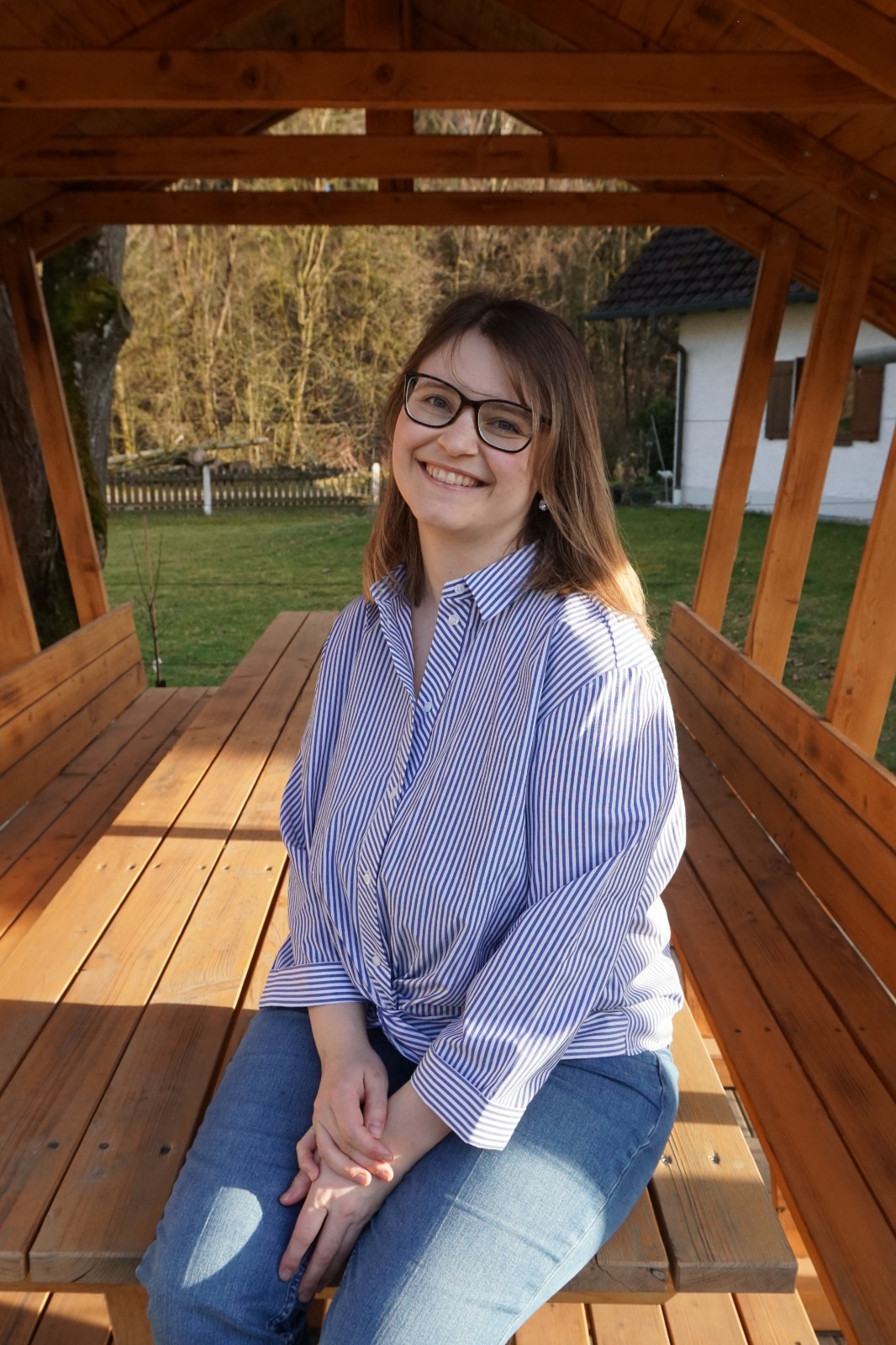 Websiteinhaberin sitzt entspannt auf Tisch und lächelt